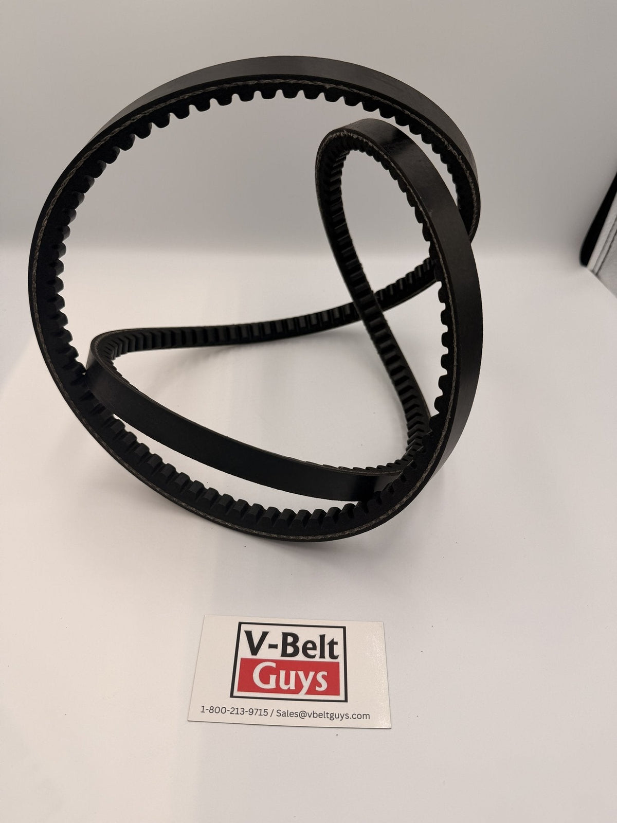 Flexible 5VX cogged wedge V-belt twisted to show the notched underside