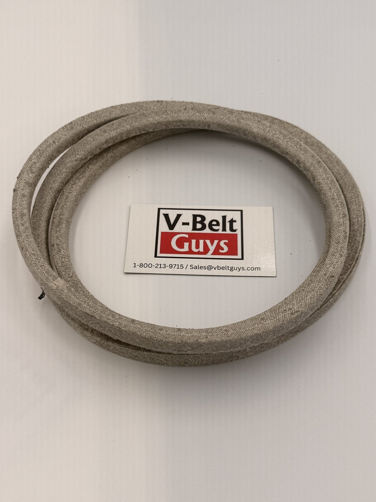Aramid wrapped V-belt coiled flat with V-Belt Guys card for scale